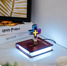 Decorative cross on a book with LED lighting, placed on a surface.