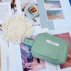 Green makeup bag with 'MAKEUP' label on a magazine spread