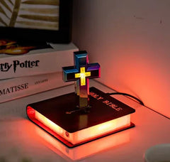 Cross-shaped lamp on a book with a blurred background