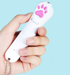 Hand holding a white remote control with a pink paw print on a light blue background