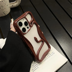 Phone case with brown design held by a hand on a wooden surface